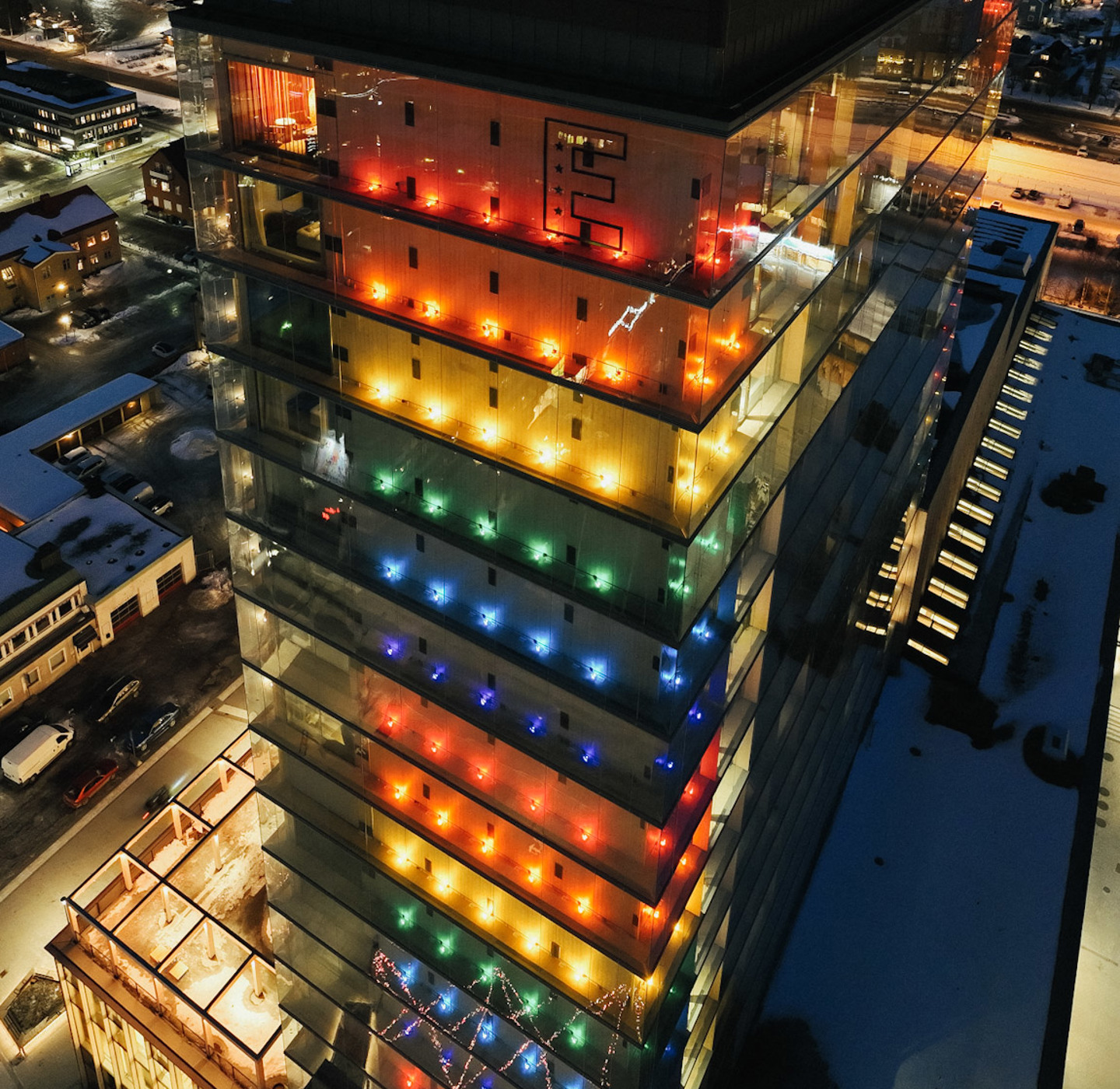 A large building lit up in pride colors. 